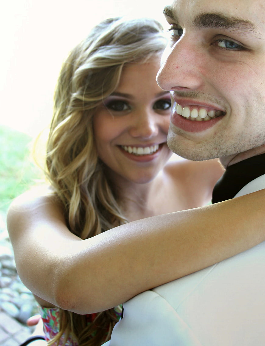 Close-up of smiling young couple embracing outdoors
