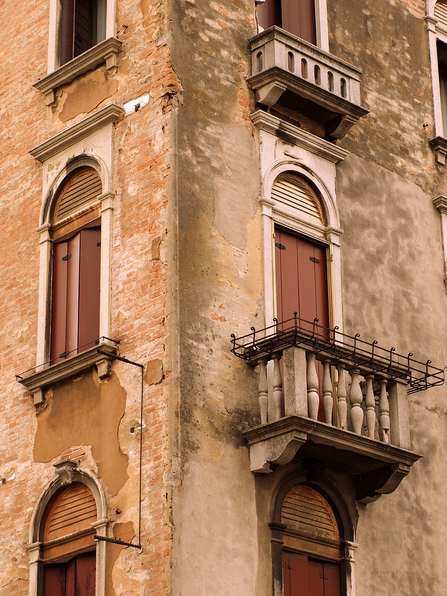 Old European Building Facade with Peeling Stucco and Balconies