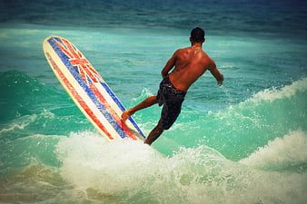 Surfer Riding Wave with Union Jack Surfboard
