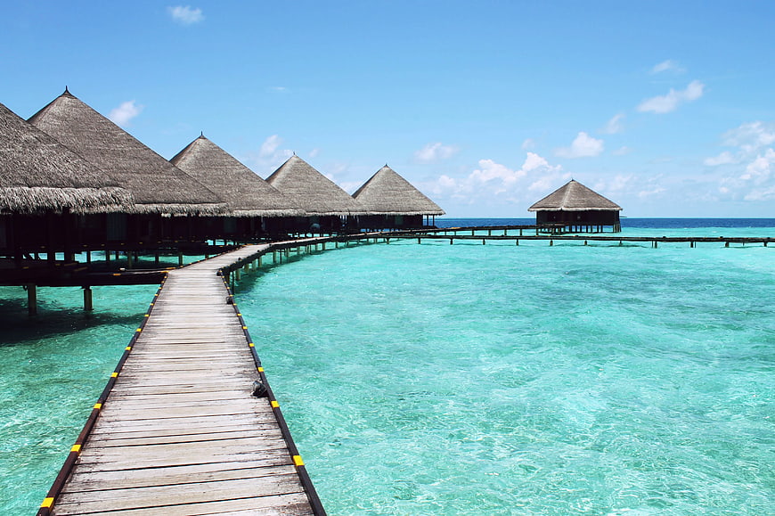 Overwater Bungalows on Wooden Walkway in Turquoise Lagoon