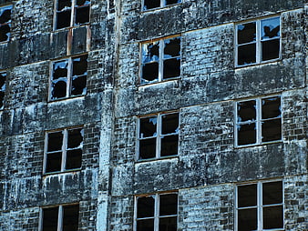 Weathered Brick Building Facade with Broken Windows