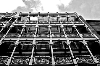 Black and white low angle view of ornate iron fire escape architecture