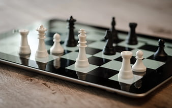 Chess pieces on tablet screen with shallow depth of field