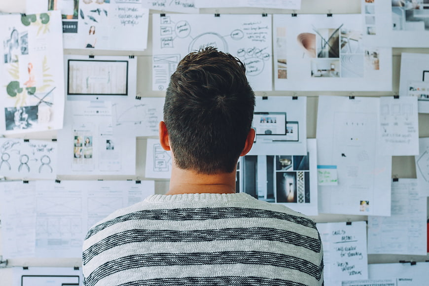 Man Analyzing Design Mood Board in Creative Workspace