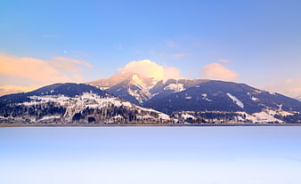 Snowy Alps Landscape with Frozen Lake and Blue Sky