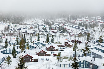 Aerial view of snowy village with red and blue houses in winter
