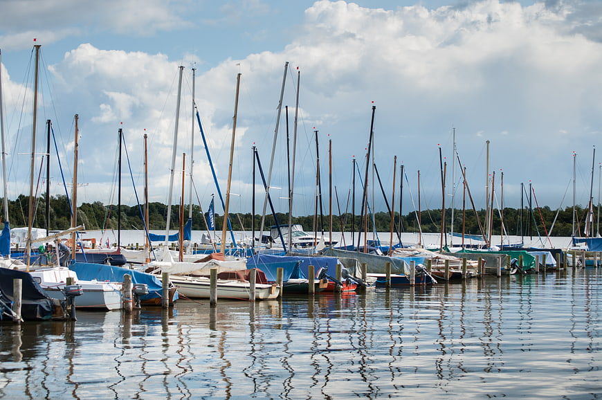 Sailboats docked in a marina with reflections on water