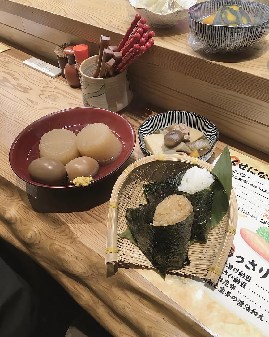 Traditional Japanese onigiri and simmered side dishes on wooden counter