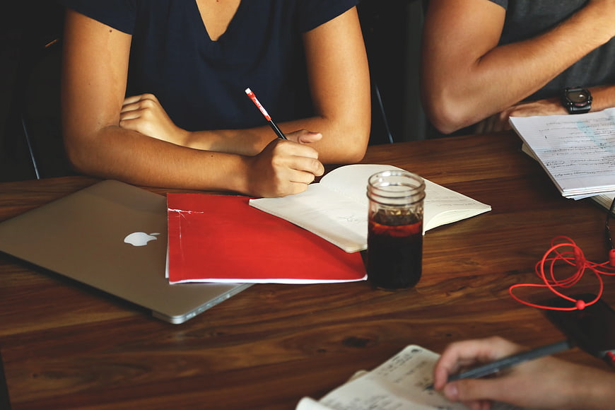 Students Studying Together at Wooden Table with Laptop