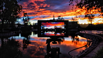 Camera Screen Capturing Vibrant Sunset Reflection Over Water