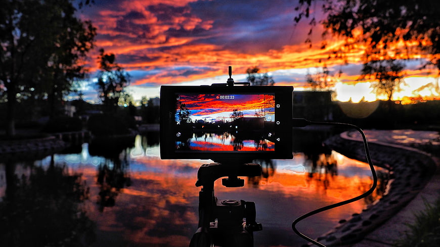 Camera Screen Capturing Vibrant Sunset Reflection Over Water