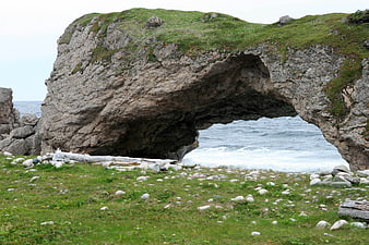 Natural Rock Arch on Grassy Coastal Shoreline