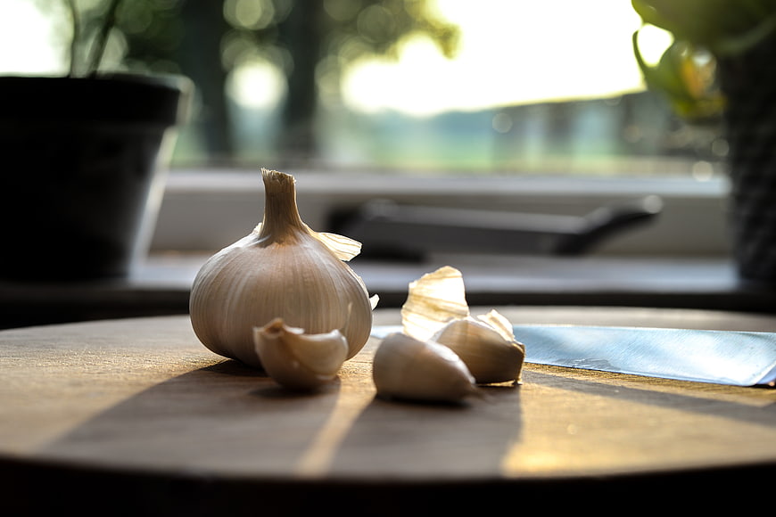 Fresh Garlic Bulb and Cloves on Wooden Board