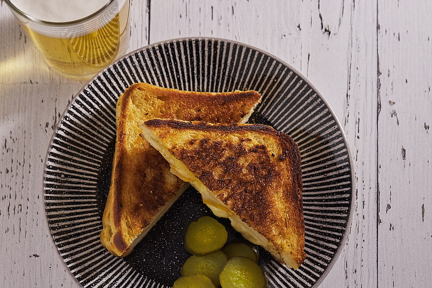 Top View of Grilled Cheese Sandwich with Pickles and Beer