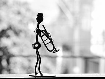 Black and white silhouette of a metal trumpet player figurine