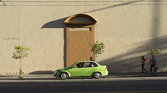 Green Car Parked on Street with Pedestrians and Wall