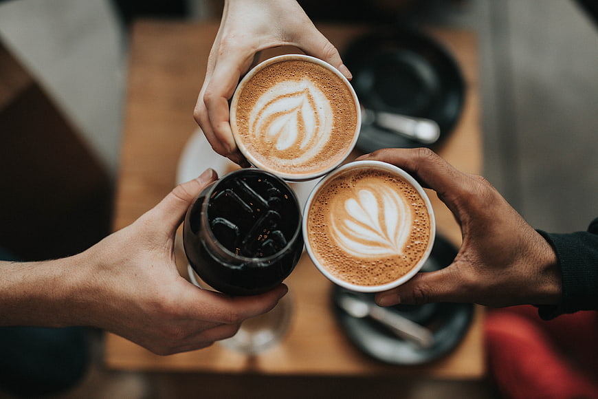 Top View of Hands Toasting with Coffee Cups
