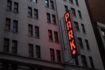 Red Neon Park Sign on Urban Brick Building Facade