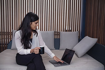 Professional woman working on laptop with coffee on patio