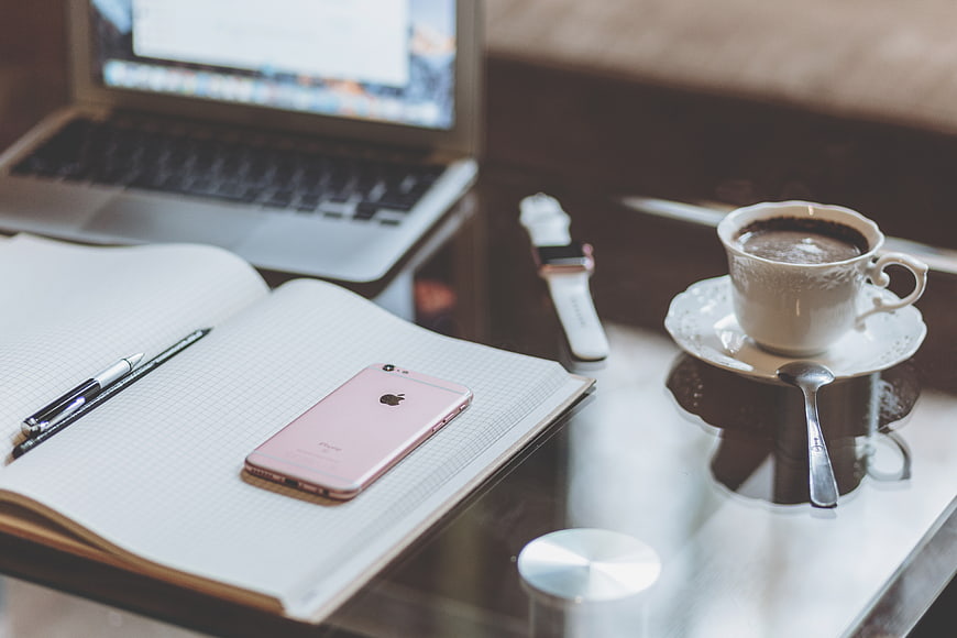 Pink iPhone on Notebook with Coffee and Laptop Workspace