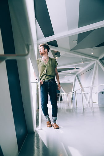 Man in Green Shirt Standing in Modern Geometric Architecture