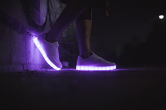 Glowing LED sneakers with purple lights at night