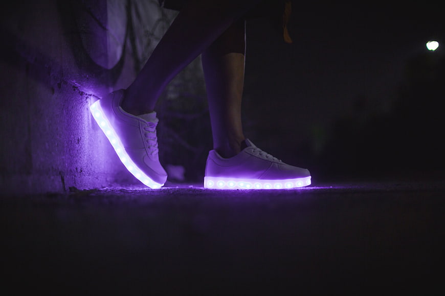 Glowing LED sneakers with purple lights at night