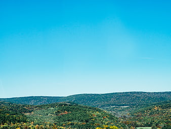 Rolling Hills Forest Landscape with Blue Sky in Autumn