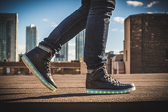 Person wearing LED light-up sneakers walking on urban rooftop