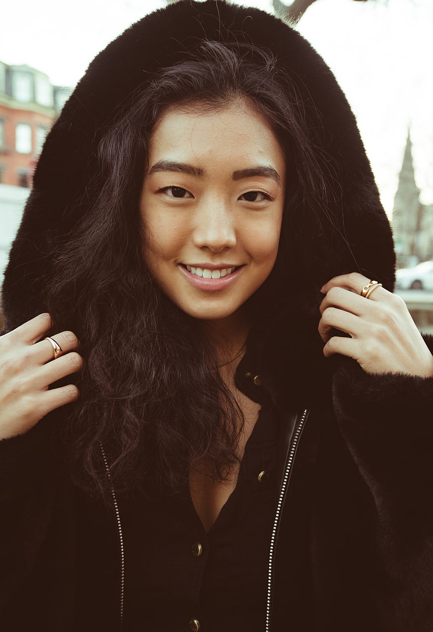 Portrait of smiling Asian woman in black fur hooded coat