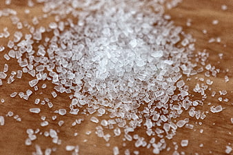 Close-up of coarse salt crystals on wooden surface