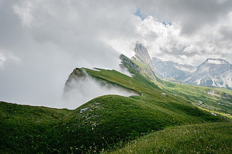 Misty green mountain landscape with dramatic clouds and peaks