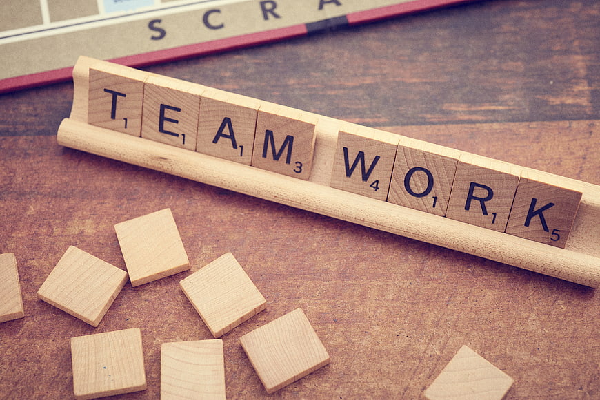 Wooden Scrabble Tiles Spelling Teamwork on Rack