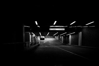 Dark monochrome parking garage with overhead lights