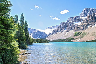 Turquoise Mountain Lake with Pine Trees and Snowy Peaks