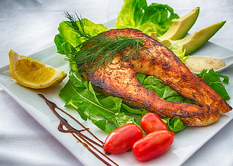 Grilled Salmon Fillet with Salad, Avocado, and Lemon on White Plate