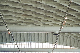 Industrial ceiling with white beams, ducts, and track lighting