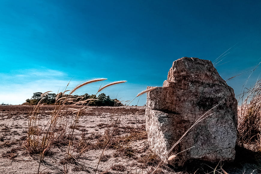 Large Boulder in Dry Field with Blue Sky