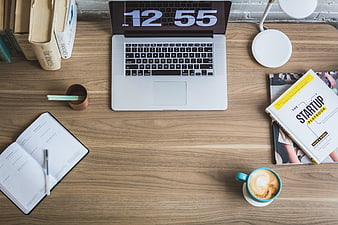 Flat lay workspace with laptop, coffee, and startup book