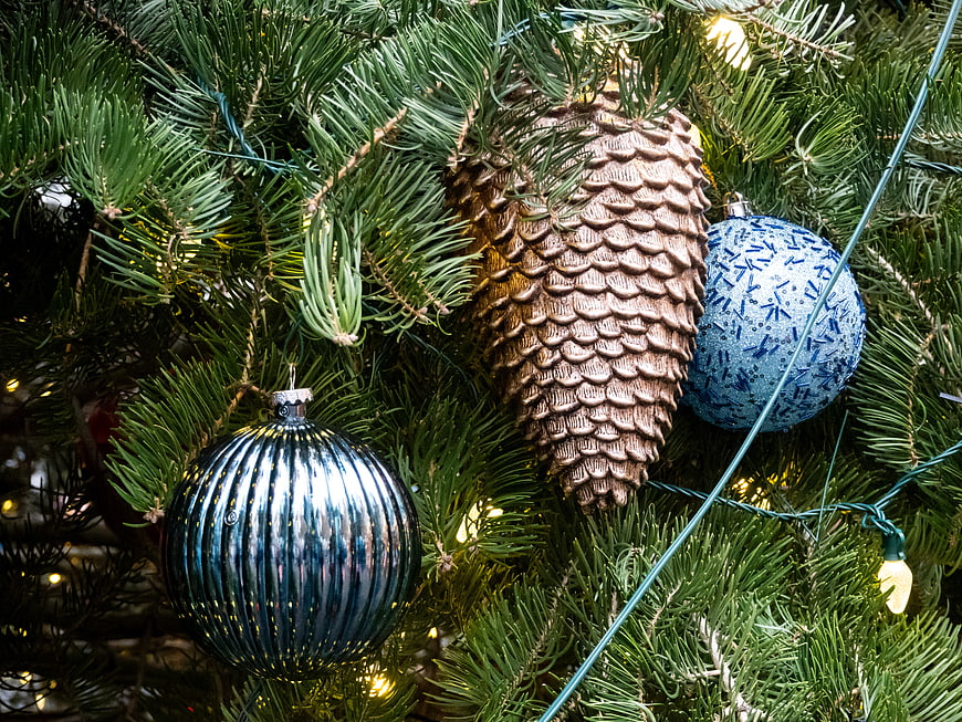 Close-up of Christmas tree with blue ornaments and pinecone