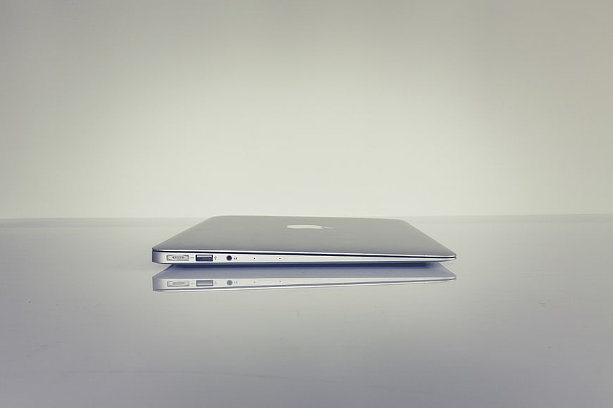 Closed Silver Laptop on White Reflective Surface