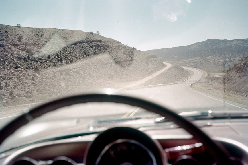 Vintage car dashboard view driving on winding desert highway
