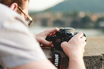 Man holding DSLR camera with blurred background