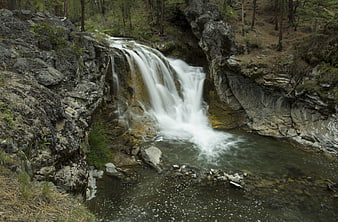 Serene waterfall cascading over rocks in a forest stream