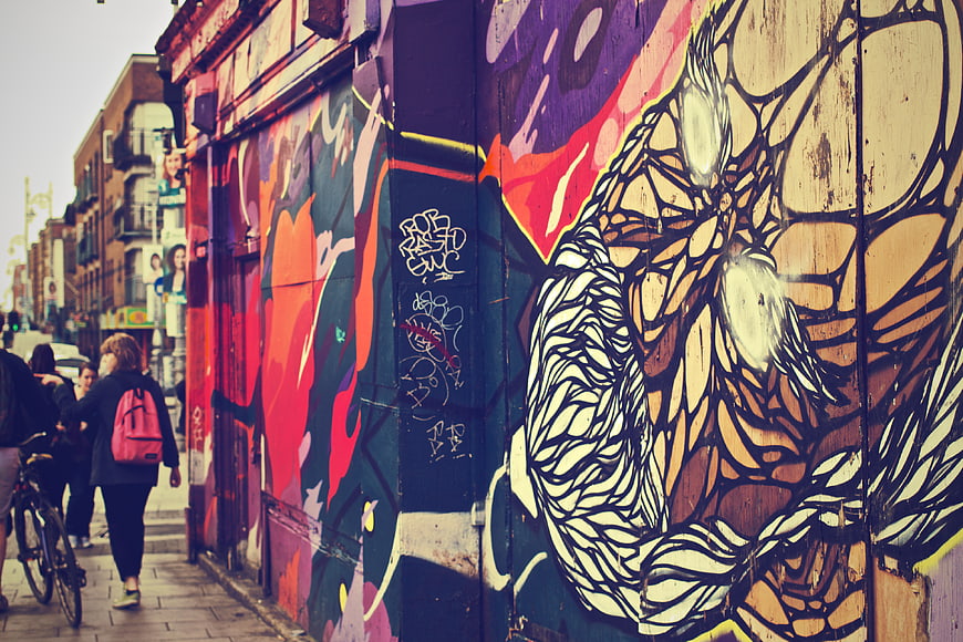 Colorful Street Art Mural on Urban Wall with Pedestrians