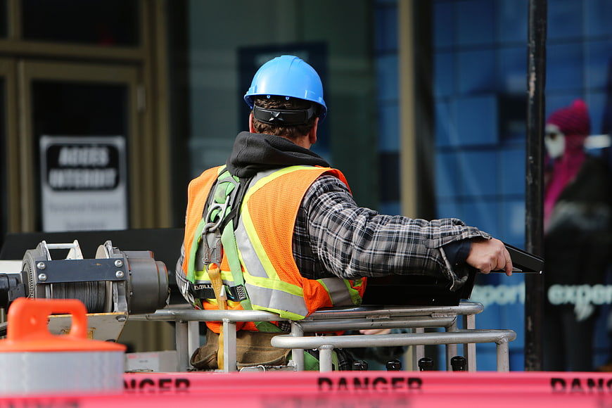 Construction worker in safety gear on lift platform