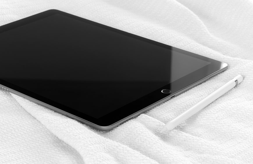 Black Tablet and Stylus on White Textured Fabric