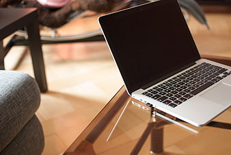 Silver laptop on glass coffee table in modern living room