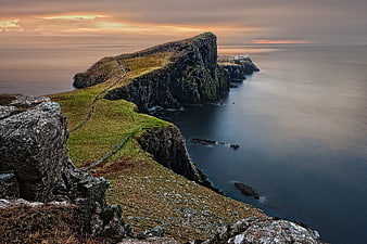 Dramatic Coastal Cliffs and Lighthouse at Sunset