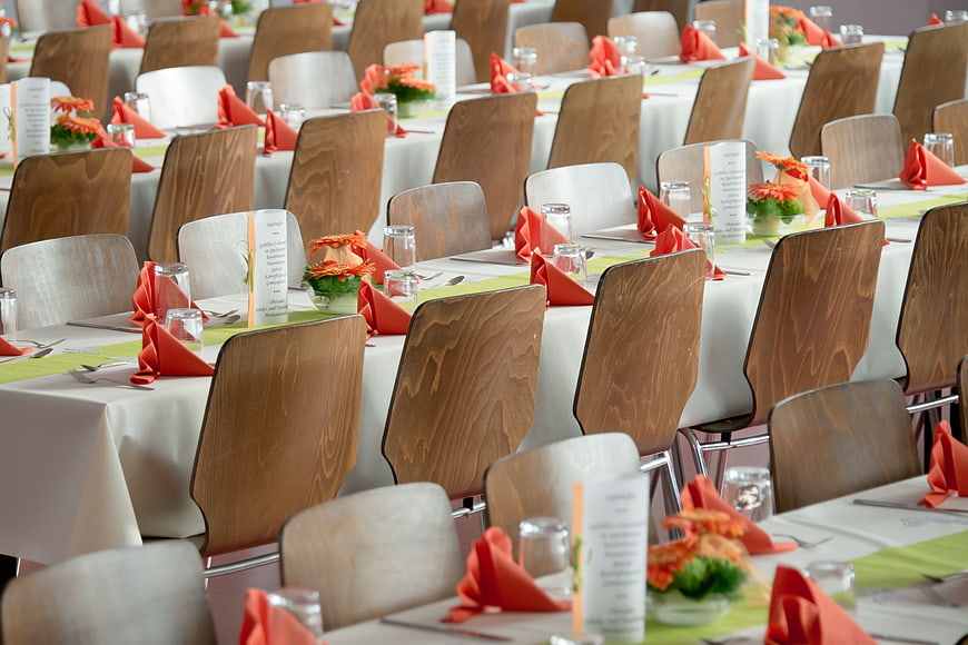 Formal Banquet Hall With Set Tables and Orange Napkins